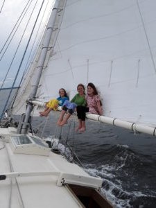 Children sitting on the boom while sailing